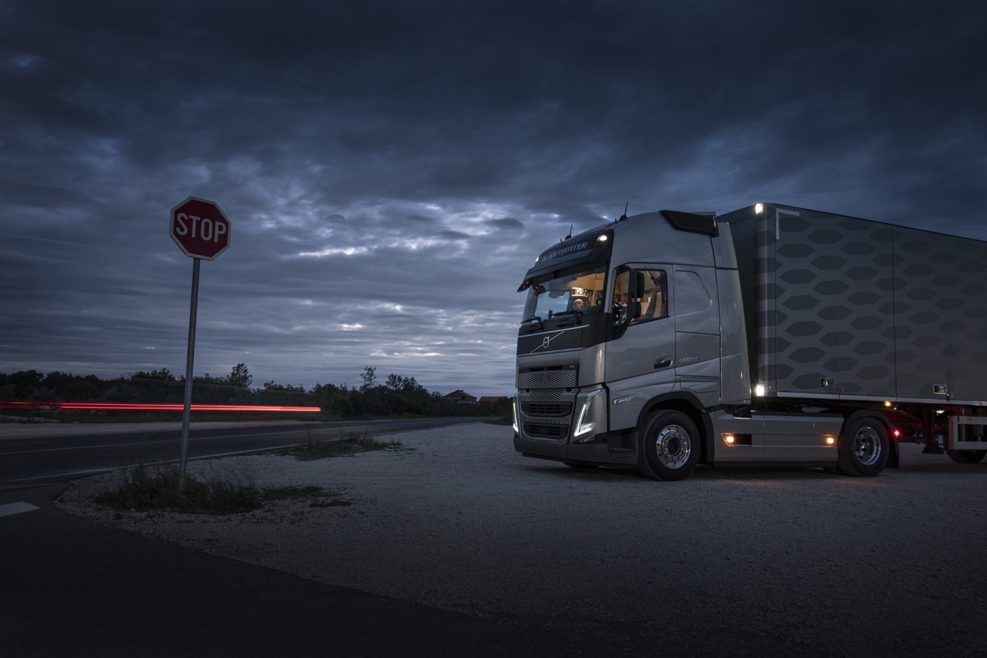 Driver resting with a coffee outside the Volvo FH16
